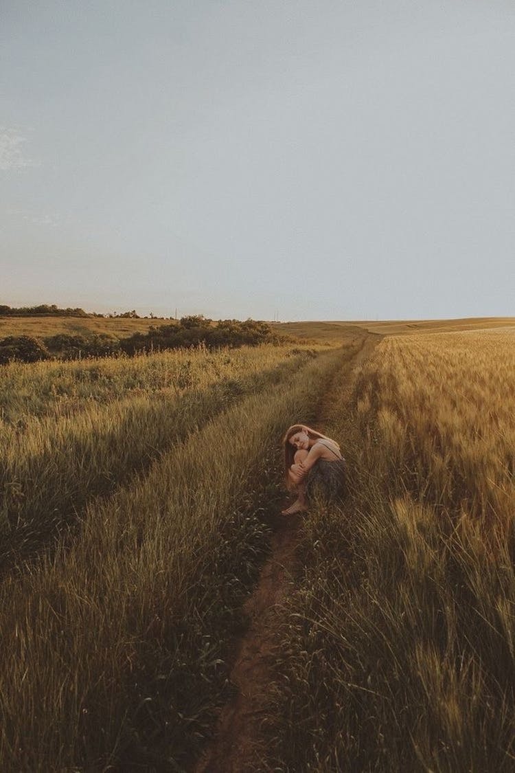 Photo Of A Girl Curled Up In A Grass Field