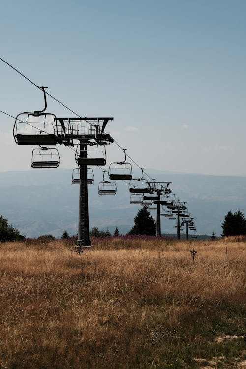 A ski lift in the mountains with a view of the sky