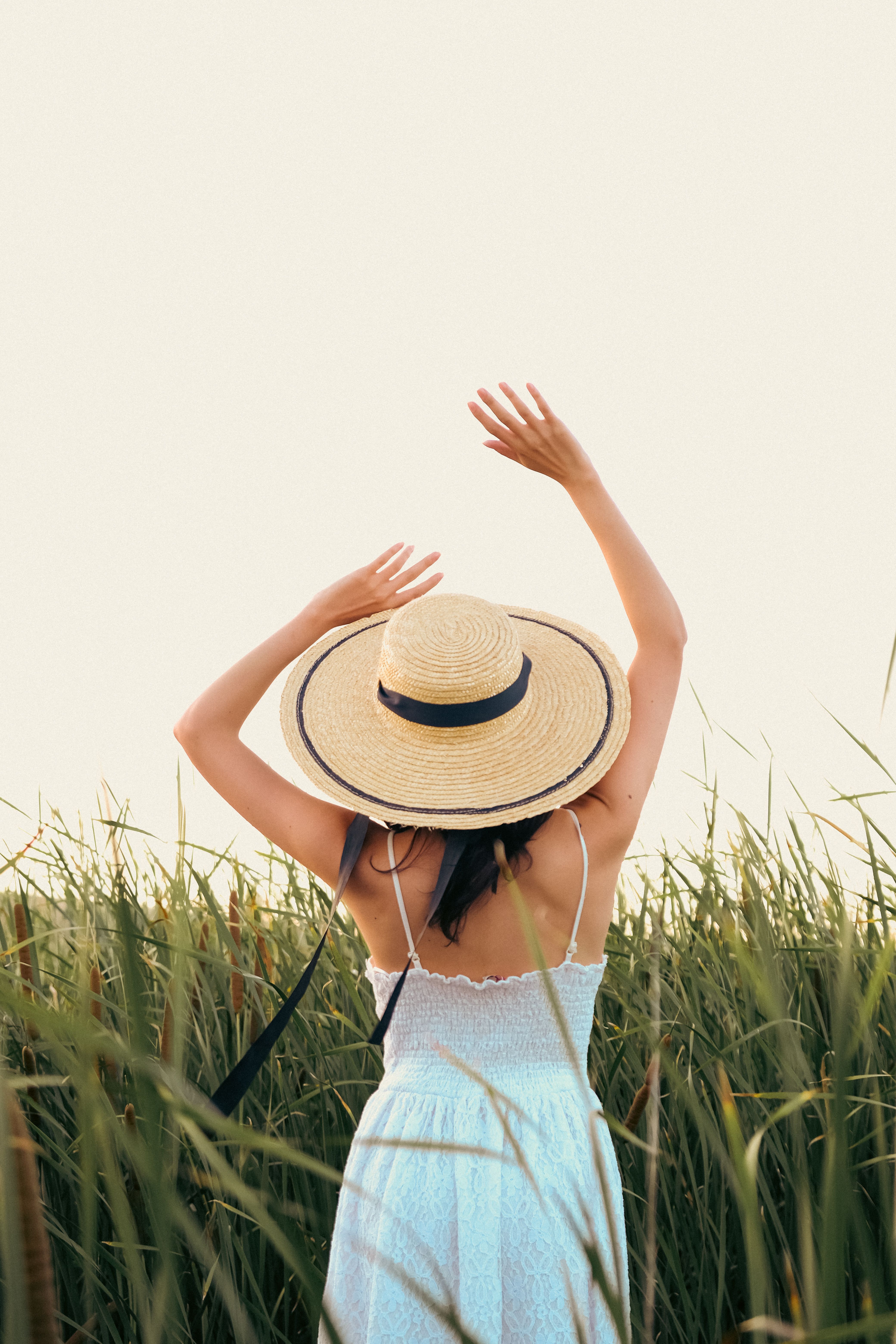 Back View of a Woman Wearing a Straw Hat, Standing in Reed Field · Free ...