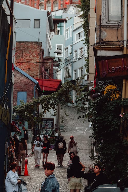 People Walking in a Cobblestone Alley between Buildings in Istanbul, Turkey 