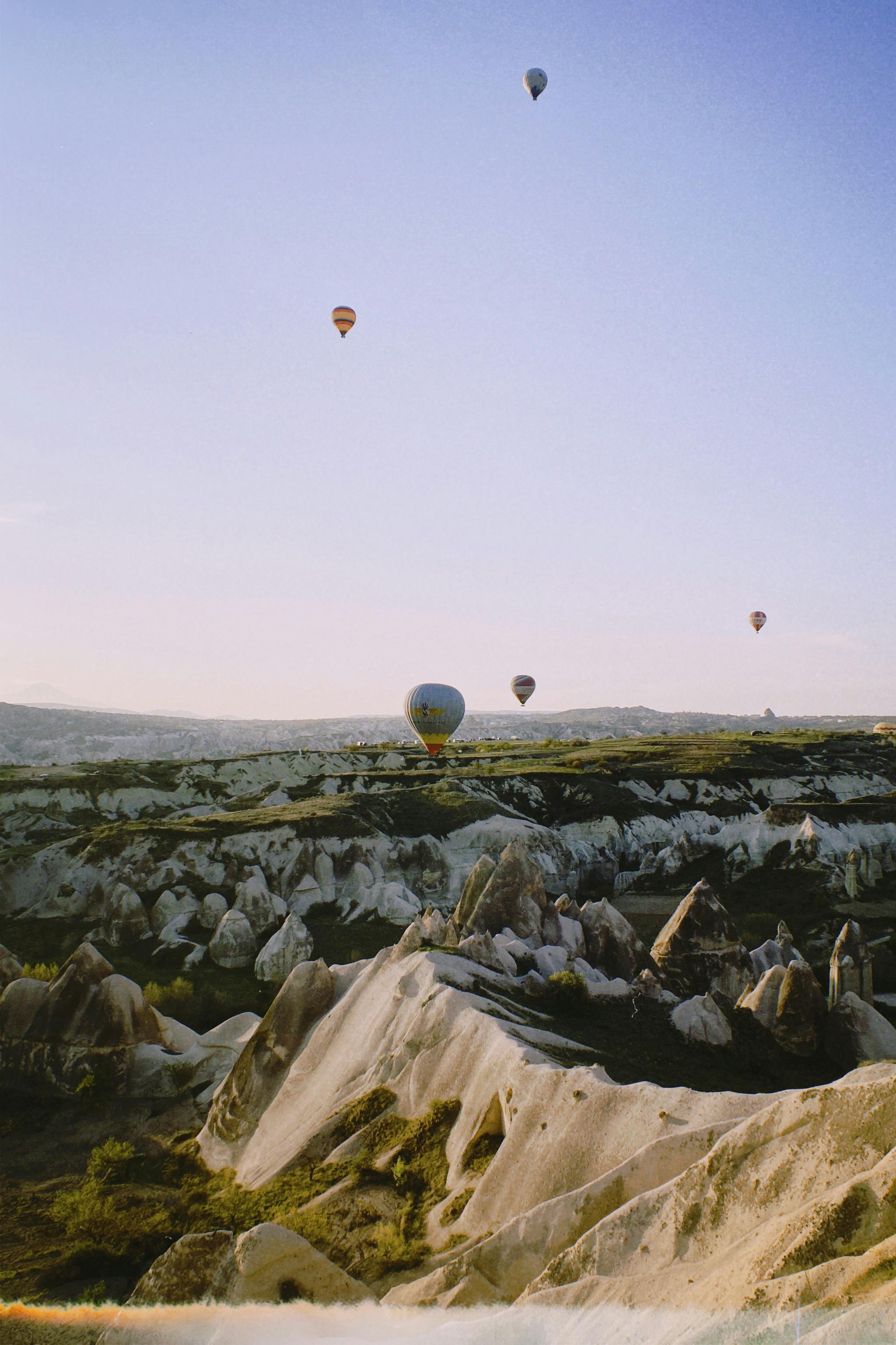 Balões de Ar Quente em Cappadocia flutuando sobre as formações rochosas únicas de chaminés de fadas de Göreme em Cappadocia, Turquia ao nascer do sol