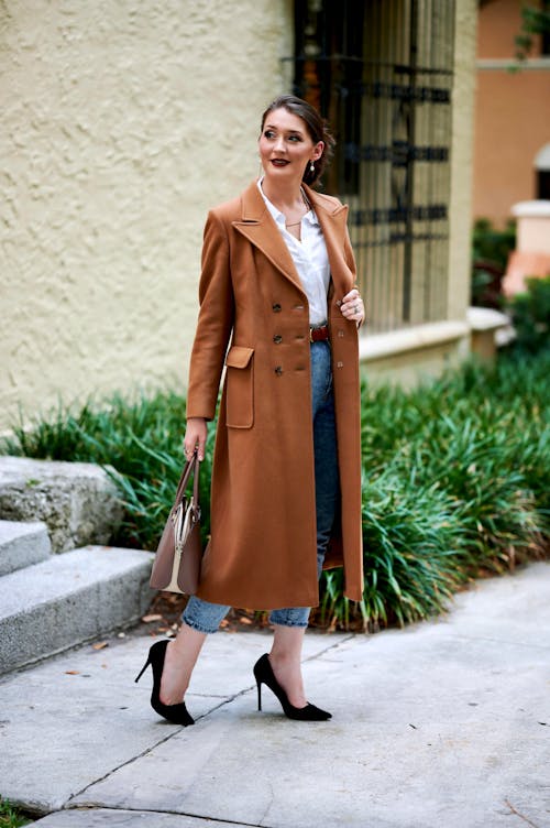 Woman in Long Brown Coat Standing on Sidewalk