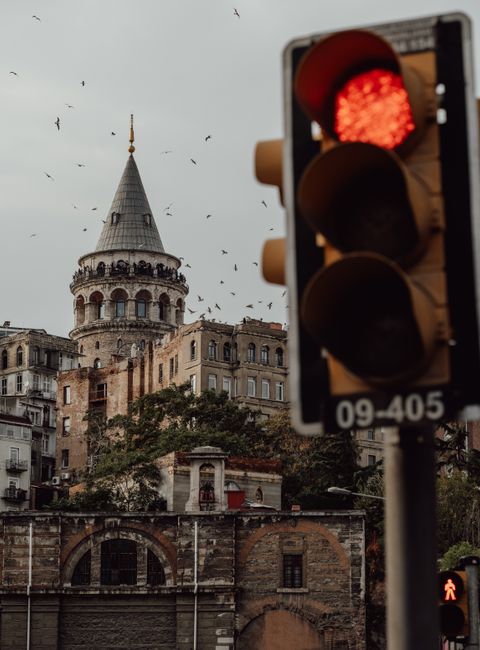 Urban scene with Galata Tower and a red traffic light in Istanbul, Turkey.