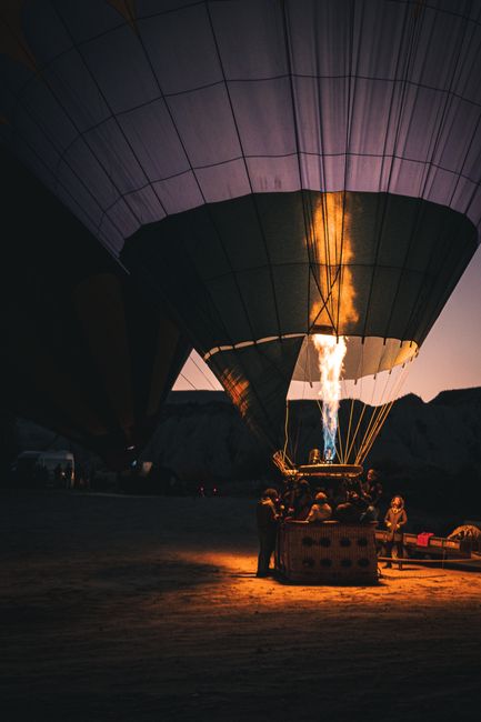 Hot air balloon illuminated at night, ready for a thrilling adventure in a rural setting.