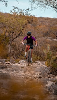 A cyclist on a rugged mountain trail, showcasing adventure sports and safety gear.