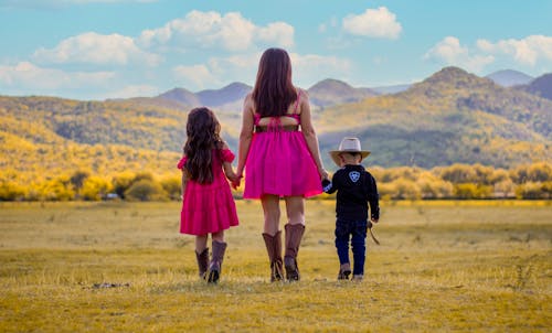 Back View of a Woman Holding Hands with her Children 