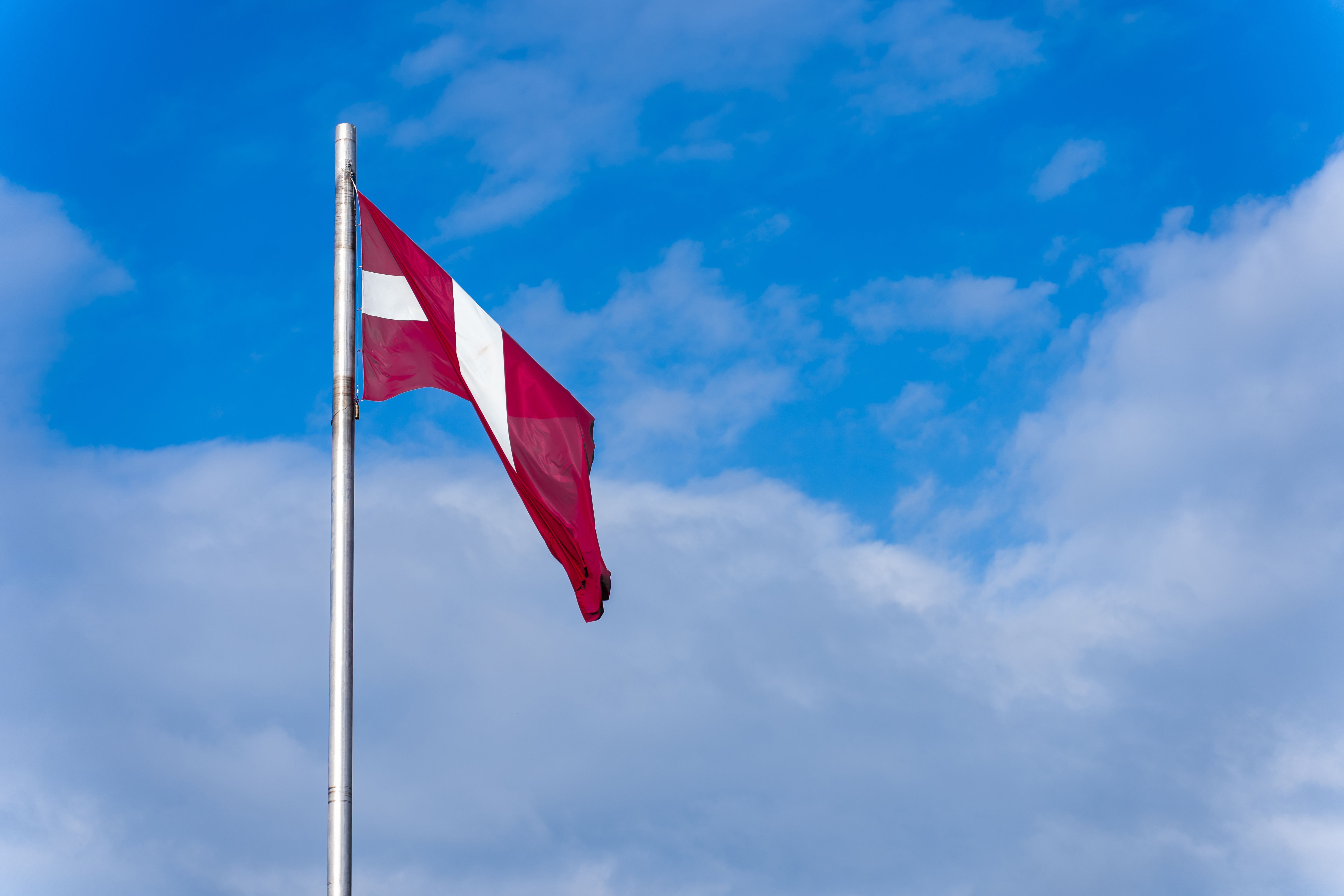 A red and white flag flying in the wind · Free Stock Photo