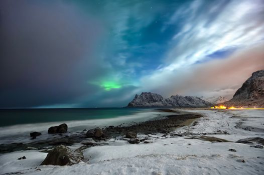 Winter beach with a brewing lady Aurora under The big Dipper
