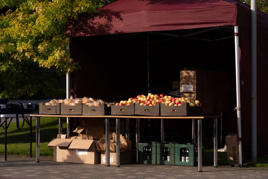 Outdoor market stall with fresh apples in autumn sunlight, ready for sale.