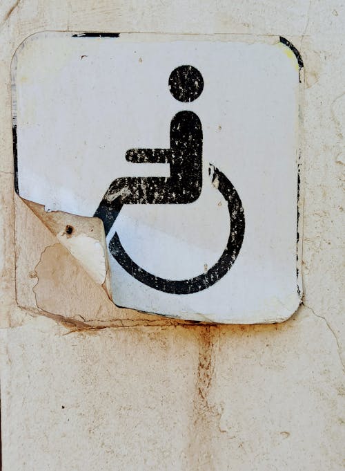 Old Handicapped Sticker Peeling off Wall