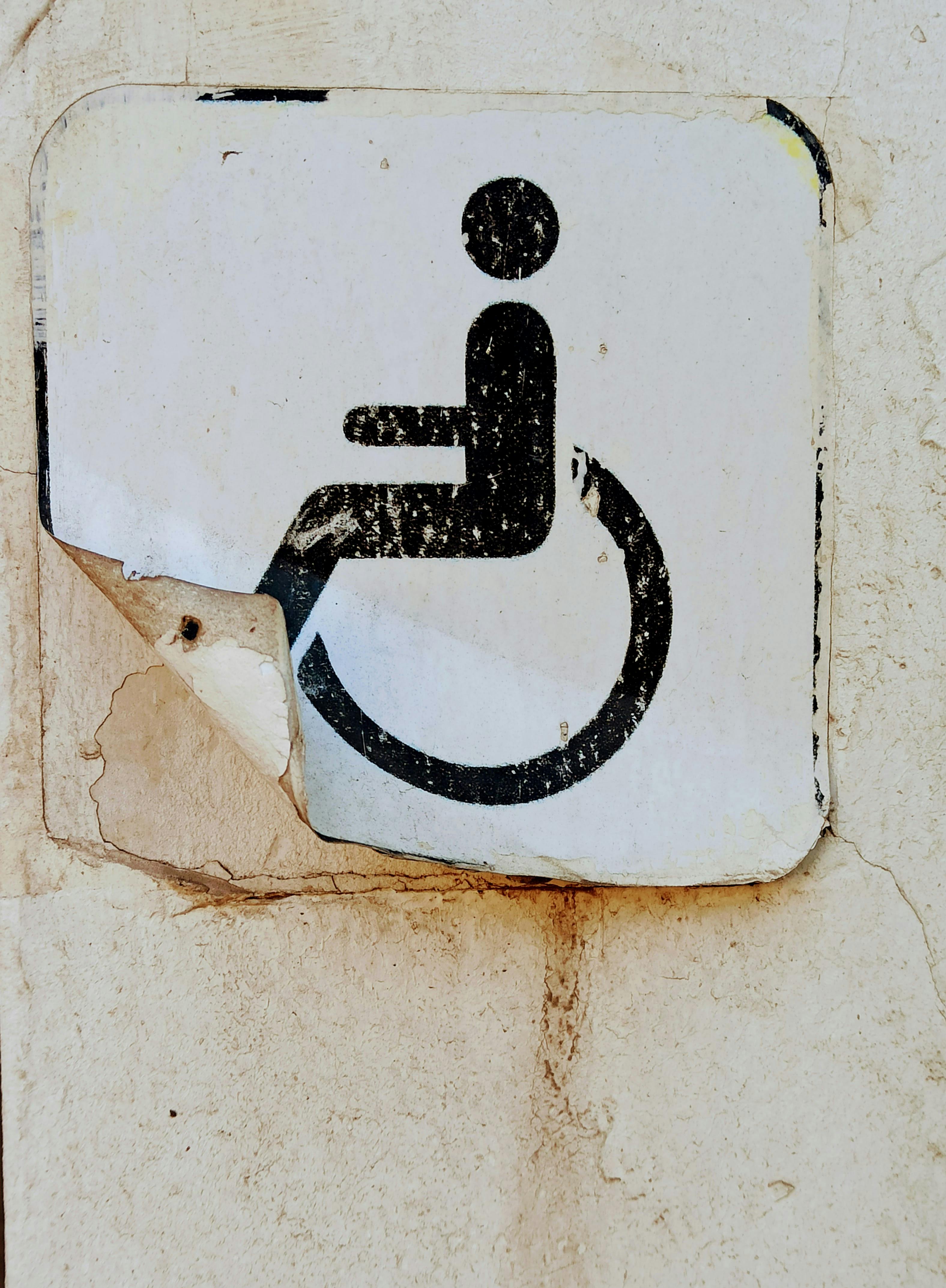Old Handicapped Sticker Peeling off Wall · Free Stock Photo