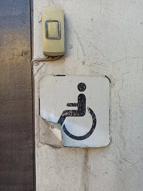 Old Handicapped Sign Peeling off Wall