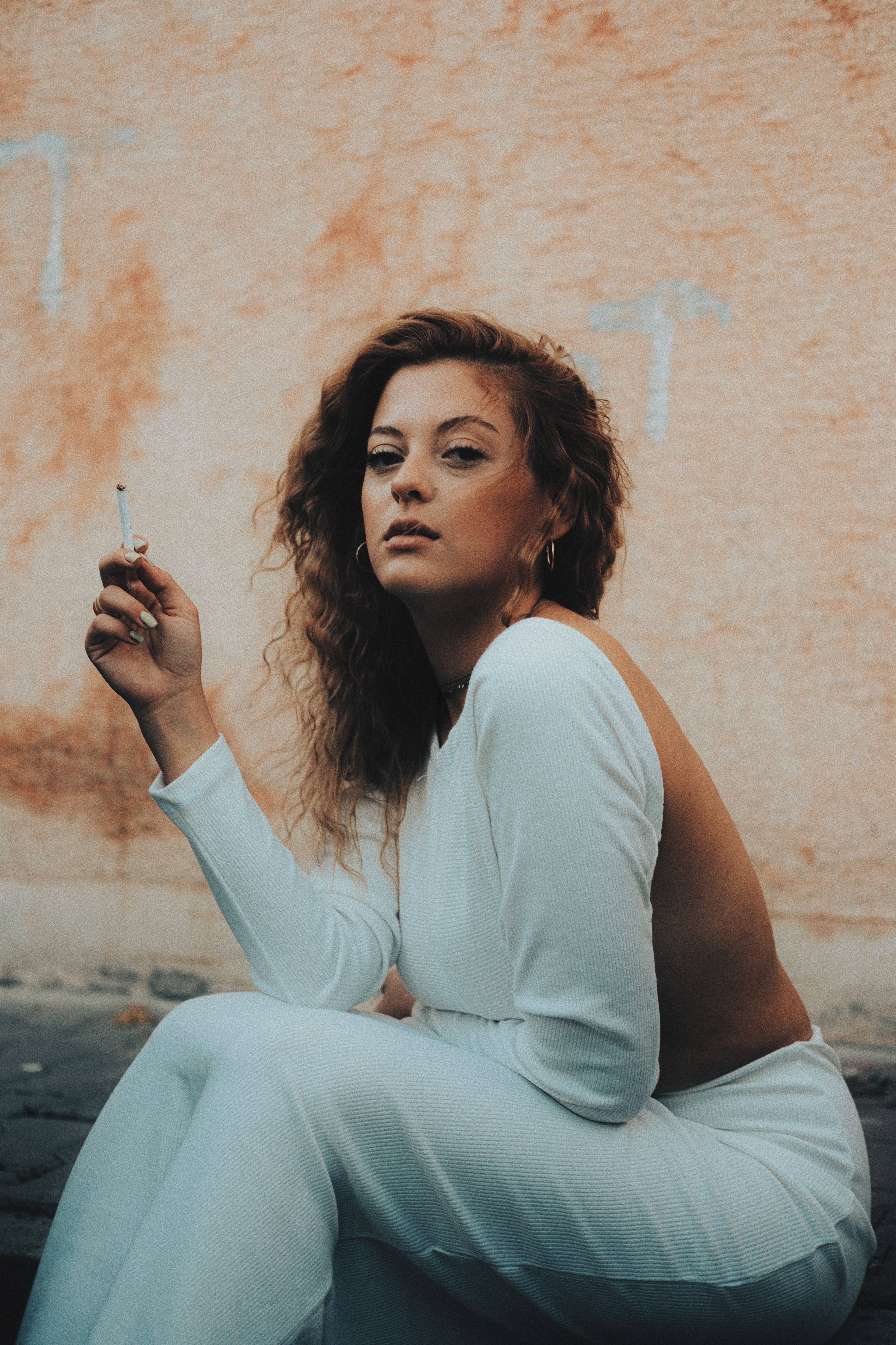 Young Woman Sitting Outside and Smoking a Cigarette · Free Stock Photo