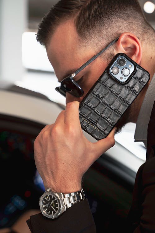 Free Handsome Gentleman Holding Crocodile Leather iPhone 15 Case by GENTCREATE Stock Photo