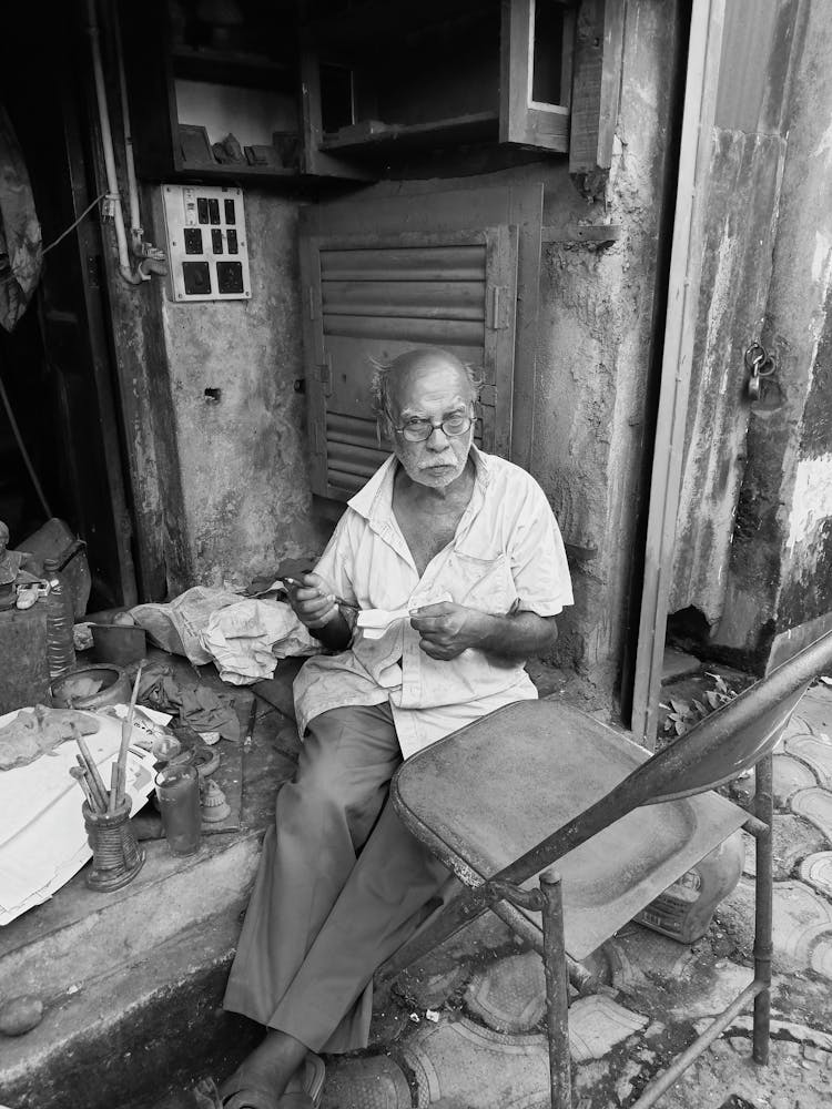 Elderly Man Sitting In The Doorway And Painting