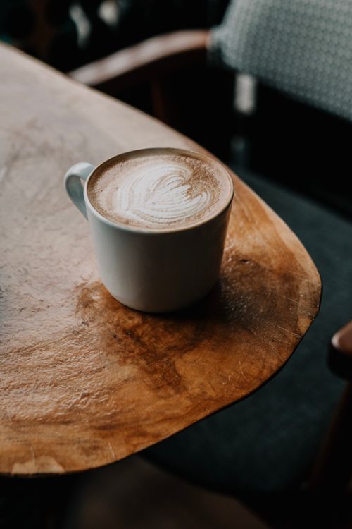 Free Captivating high-angle view of a frothy cappuccino on a rustic table, perfect for cozy moments. Stock Photo