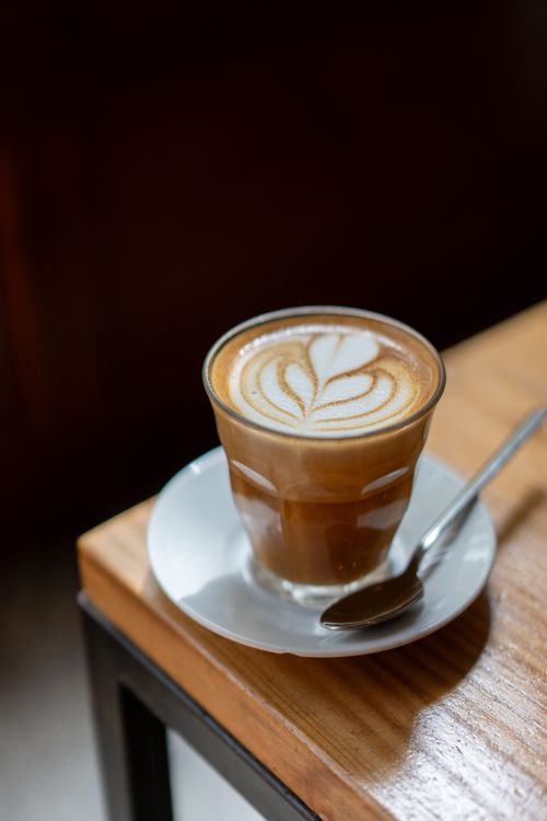 Free Beautifully crafted cappuccino with latte art on a café table, perfect for coffee lovers. Stock Photo