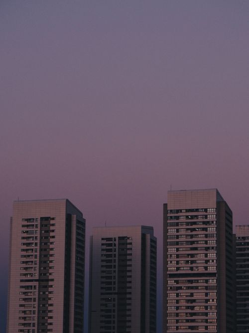 Free A mesmerizing view of modern skyscrapers silhouetted against a soft purple twilight sky. Stock Photo
