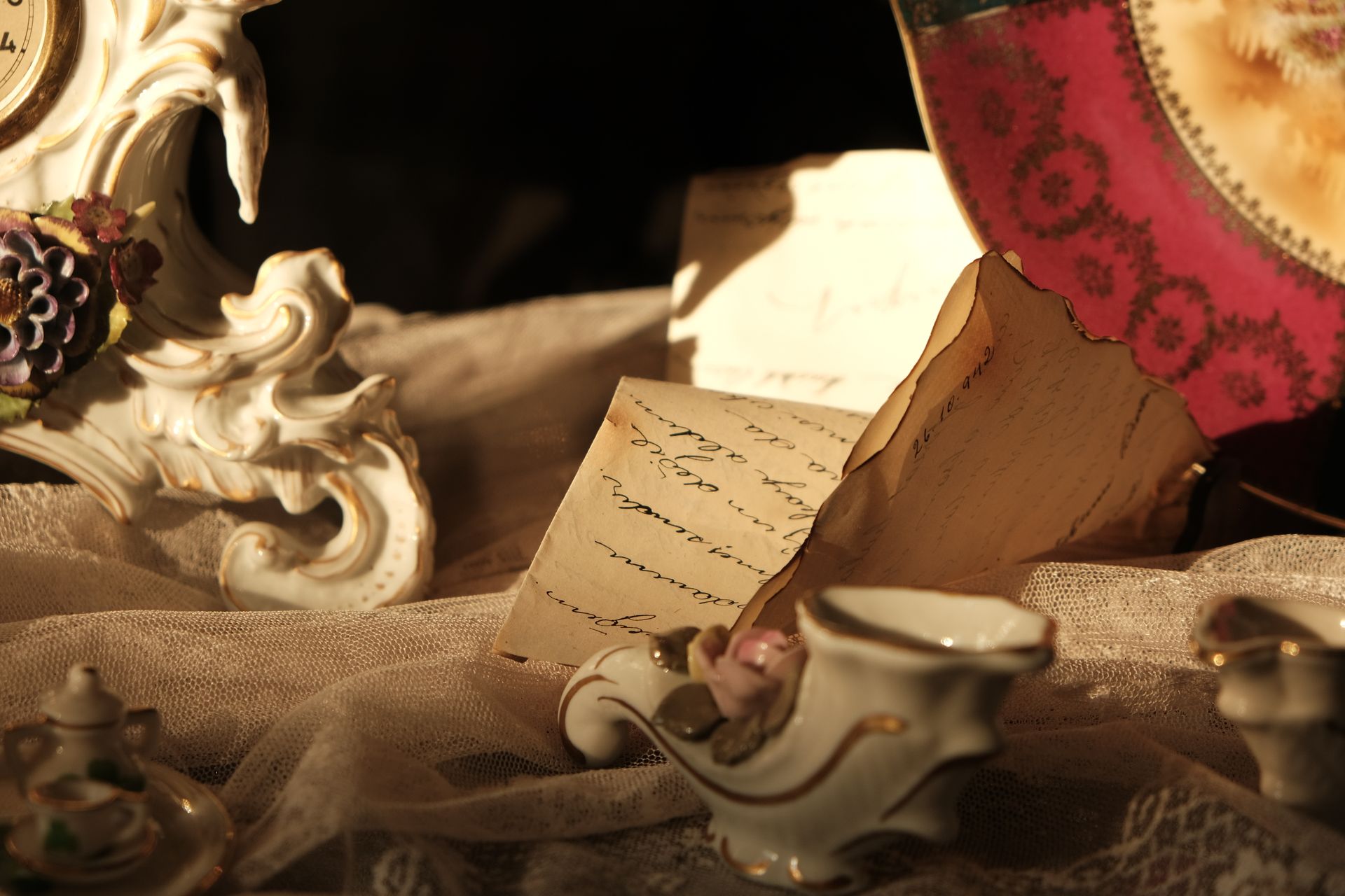 Elegant display of antique porcelain and handwritten letters in soft light.