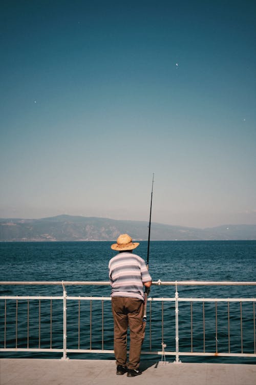 Back View of a Man Fishing from a Pier