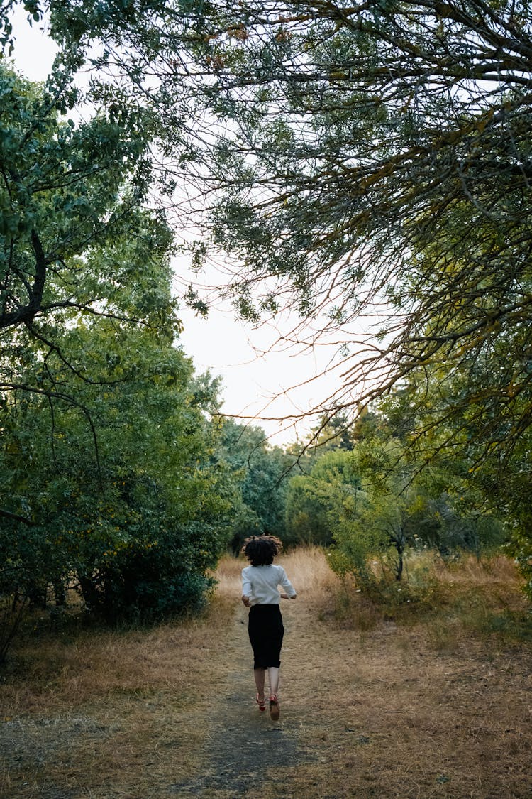 Woman Running On Footpath In Forest