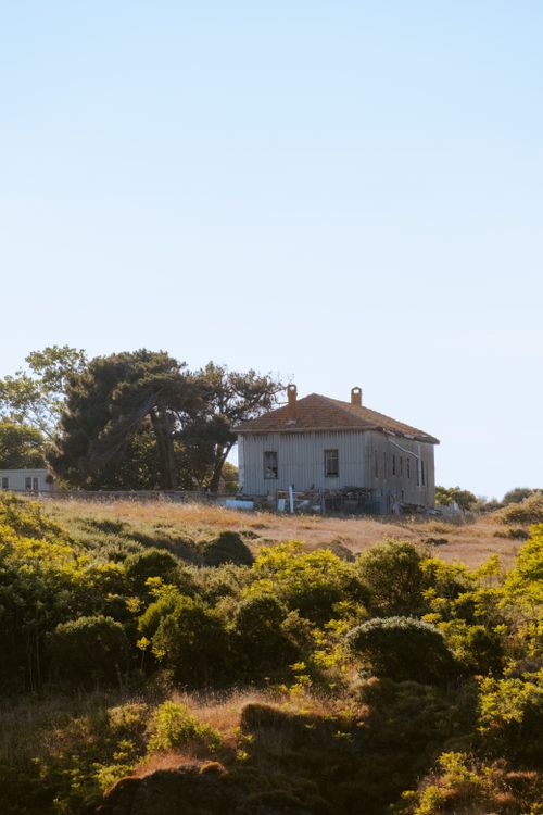 Free Charming house nestled in a lush rural setting under a clear blue sky. Stock Photo