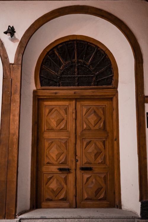 Free A classic wooden door framed by an intricate archway, showcasing vintage architectural style. Stock Photo
