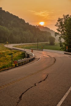 A peaceful sunrise over a winding rural road in West Albany, MN, captured in early morning fog.