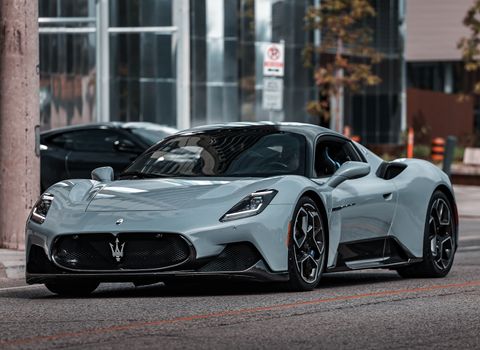 Elegant Maserati MC20 supercar parked on an urban street, showcasing modern luxury.