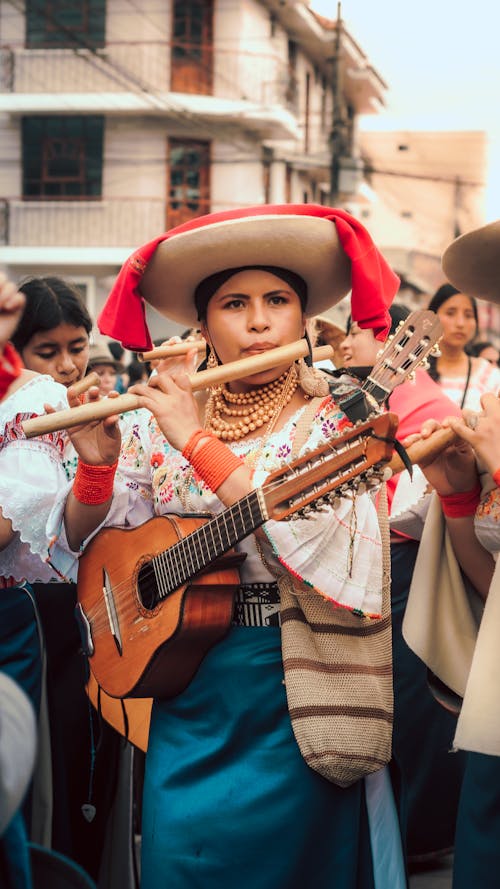Woman with Guitar Playing Flute during Parade