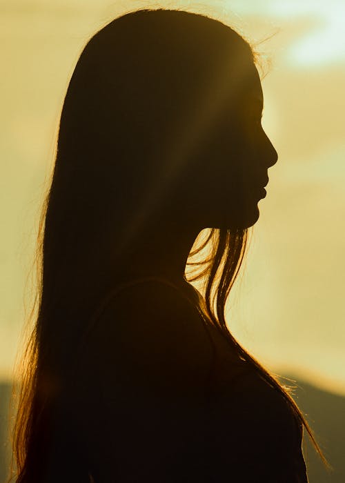 Back Lit Silhouette of a Young Long Haired Woman