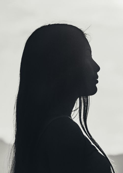 Free Artistic black and white silhouette portrait of a woman standing against a bright sky in Otavalo, Ecuador. Stock Photo