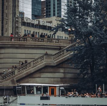 Tourists exploring the iconic steps of the Chicago Tribune in downtown Chicago.