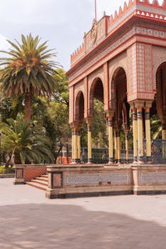 Beautiful view of Mexico City's Morisco Kiosk surrounded by palm trees in Alameda Park.