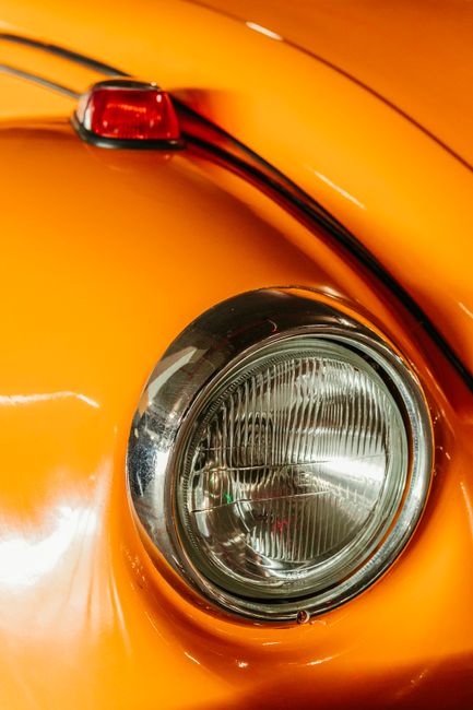 Detailed close-up of an orange vintage car headlight with a shiny surface.