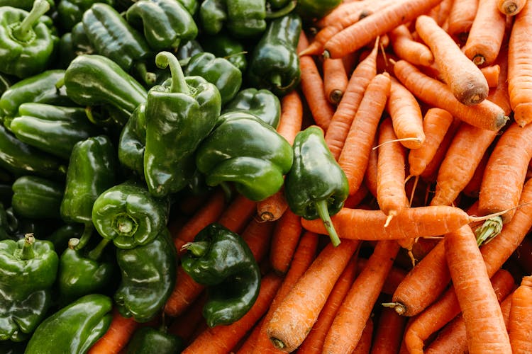 Pile Of Green Bell Peppers And Orange Carrots