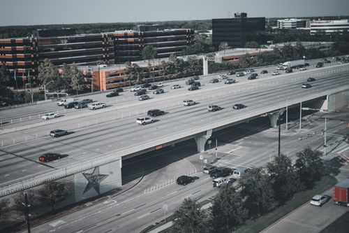 Free Aerial view of a busy urban highway with cars and trucks during the day. Stock Photo