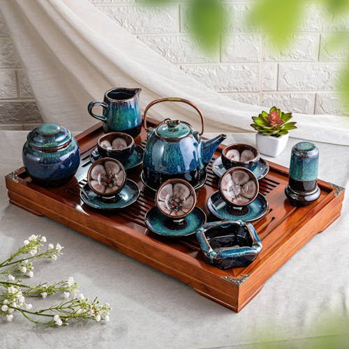 A Ceramic Tea Set Standing on a Wooden Tray 