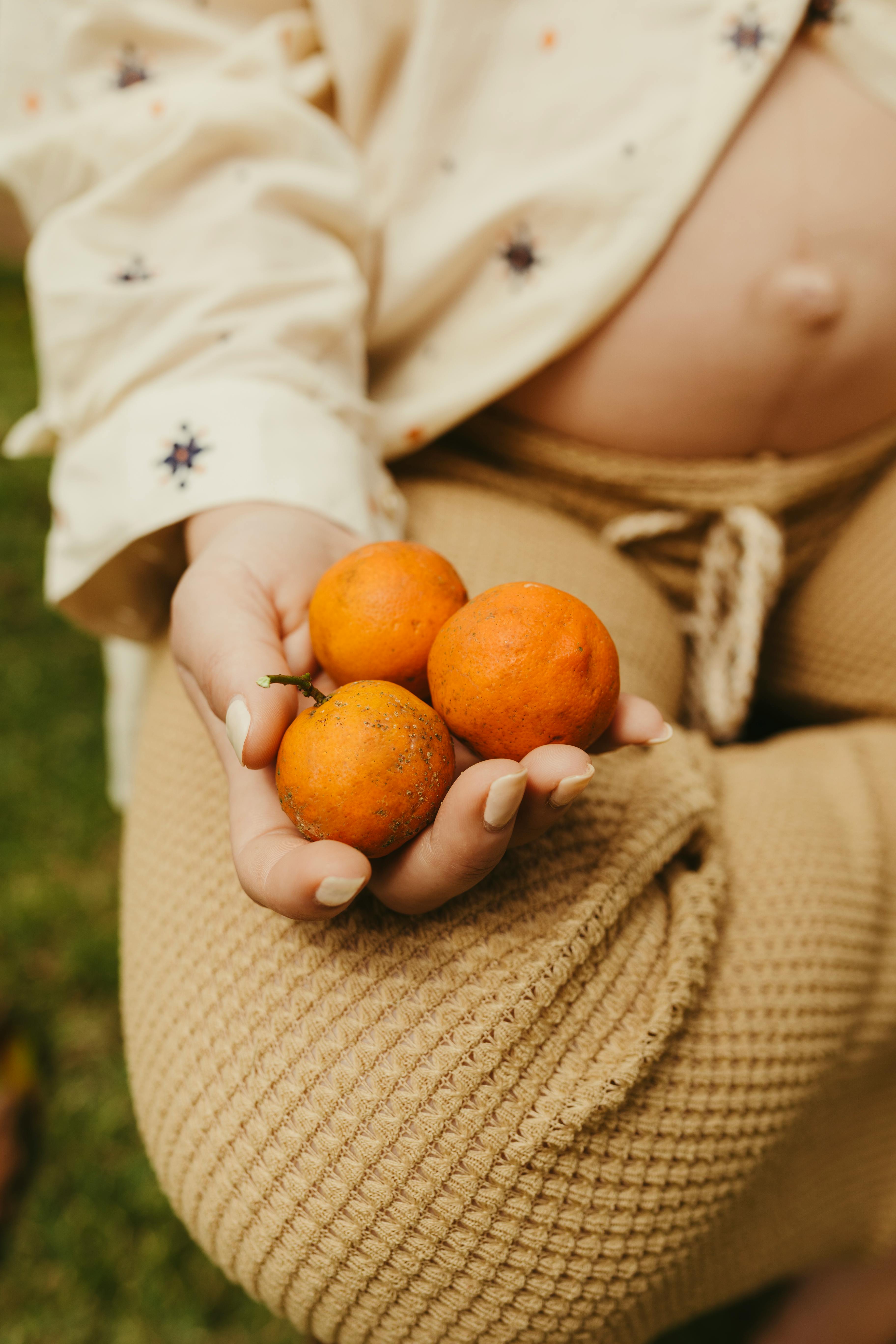Pregnant Woman Holding Tangerines · Free Stock Photo