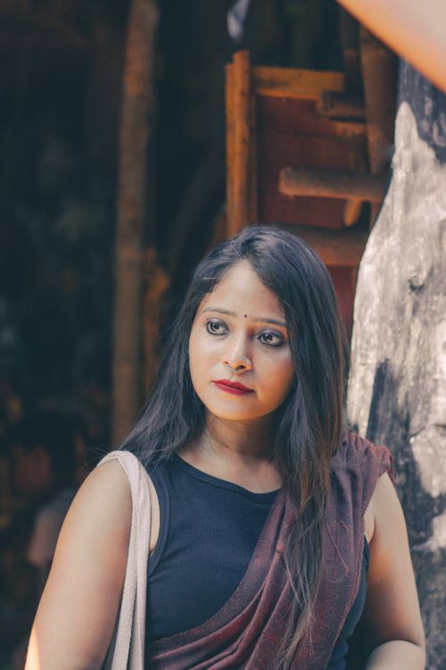 Free A woman with long black hair in traditional attire poses outdoors, showcasing cultural beauty. Stock Photo