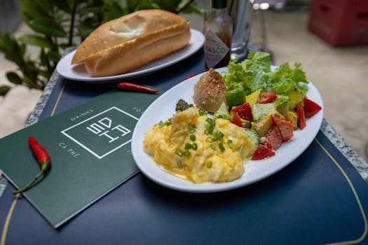 A scrumptious meal featuring scrambled eggs, fresh bread, salad, and spices. Perfect breakfast setting.
