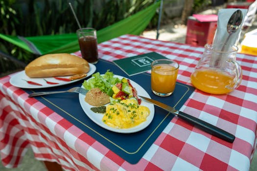 Delicious outdoor breakfast setting with scrambled eggs, salad, bread, and fresh orange juice.