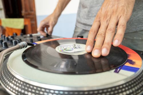 Free Close-up of a DJ using a turntable to mix vinyl records indoors. Stock Photo