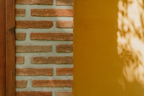 Yellow Paint near Bricks on Wall
