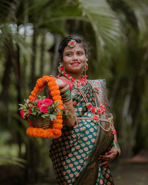 A Pregnant Woman in Traditional Clothing and Jewelry Posing Outside