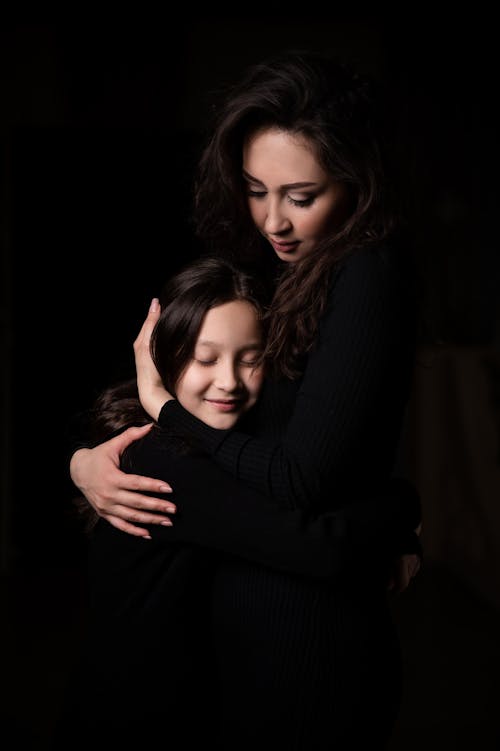 Mother Hugging Daughter in Darkness