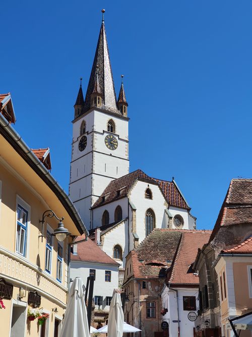 Free Magnificent Gothic church tower rising above the charming streets of Sibiu, Romania. Stock Photo