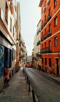 A vibrant urban street scene showcasing colorful buildings along a narrow roadway in a city district.