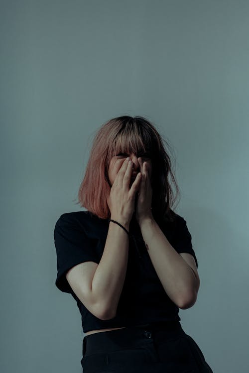 Free Young Woman Covering her Face with Hands Stock Photo