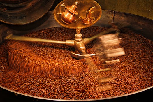 A close-up view of coffee beans being roasted in an industrial drum roaster.